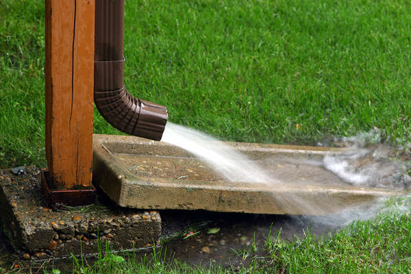 A gutter redirecting water flow into a different part of yard.