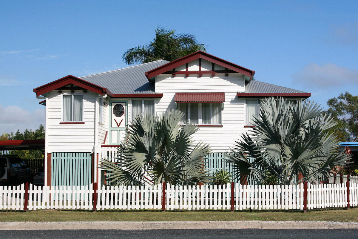 white and brown house exterior with matching picket fence