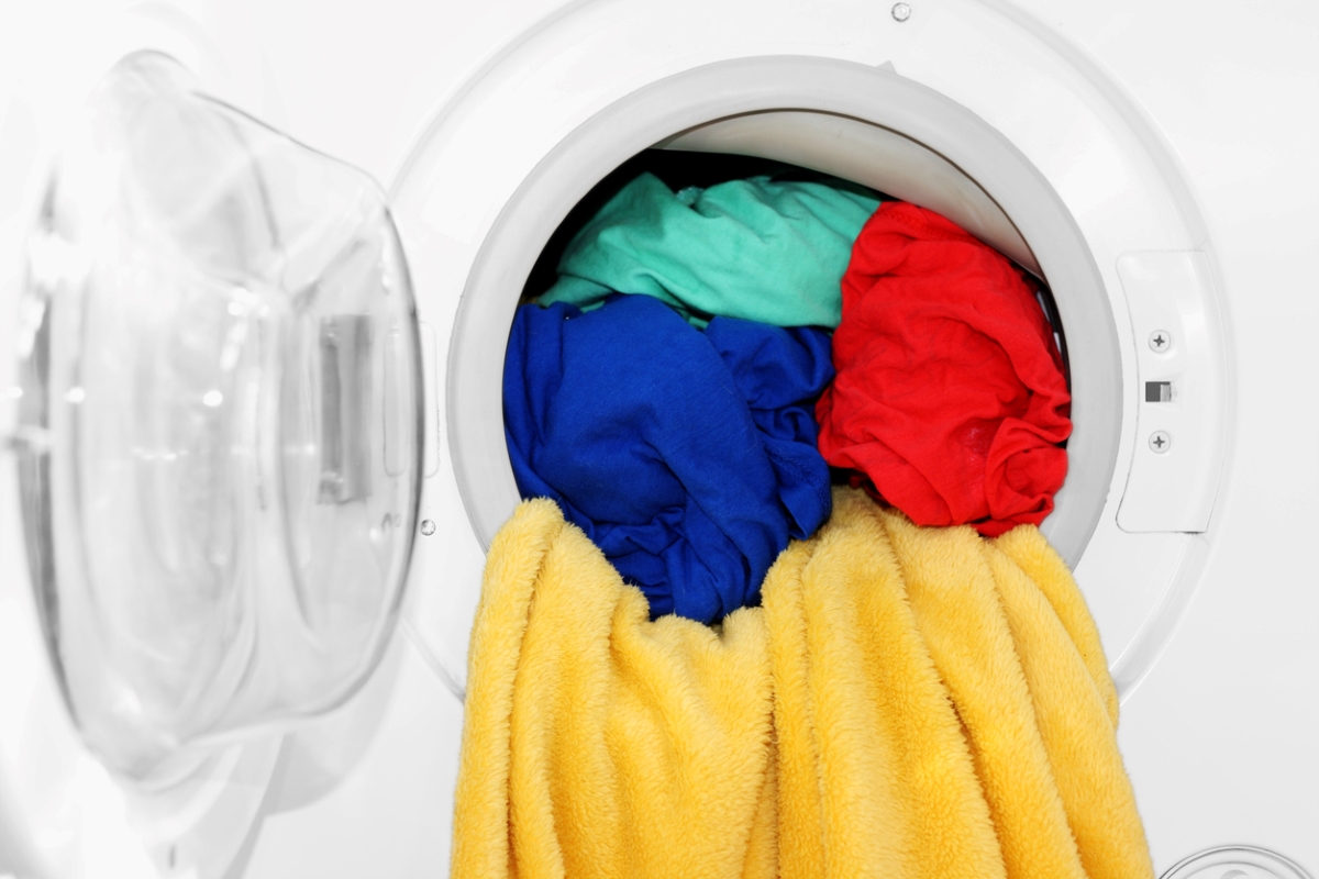 Colorful laundry spilling out of washer