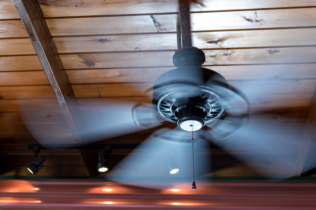 A ceiling fan shows motion blur as its blades rotate.