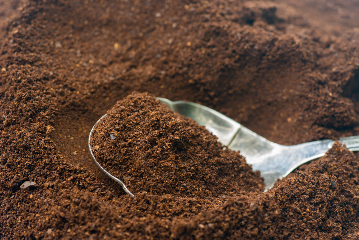 close up shot of spoon scooping up coffee grounds