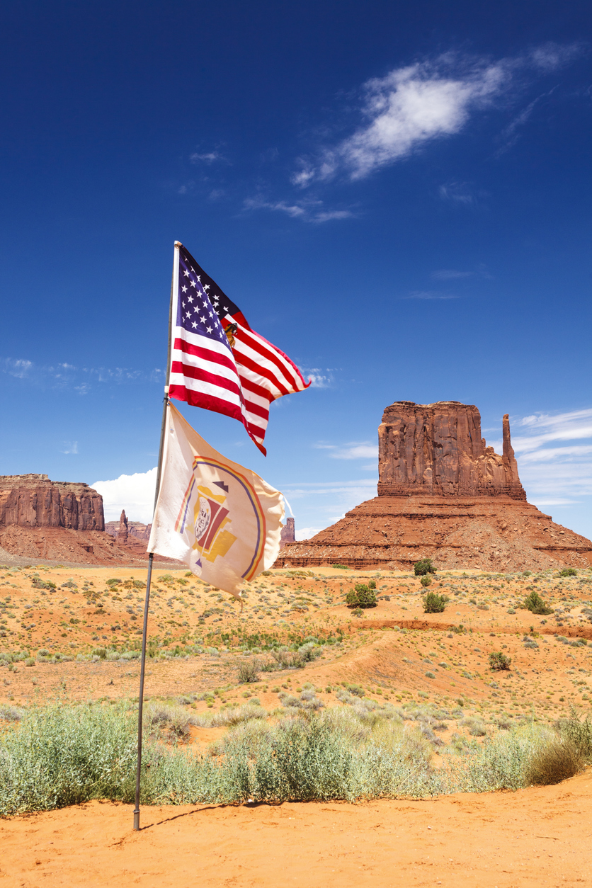 American flag and flag of the Navajo Nation. West Mitten Butte in background, Monument Valley Navajo Tribal Park, Arizona, United States.