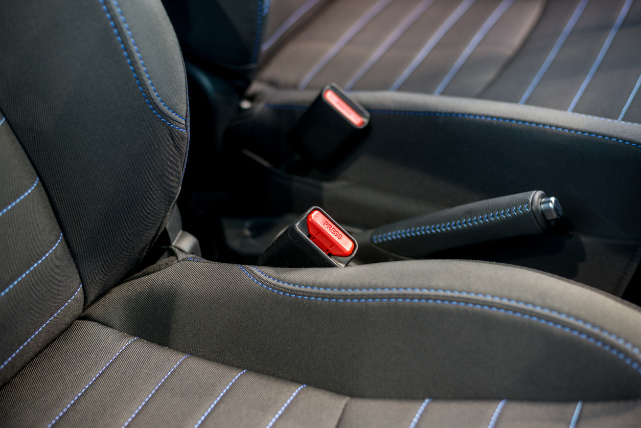 close view of dark colored car seats with seatbelt buckles