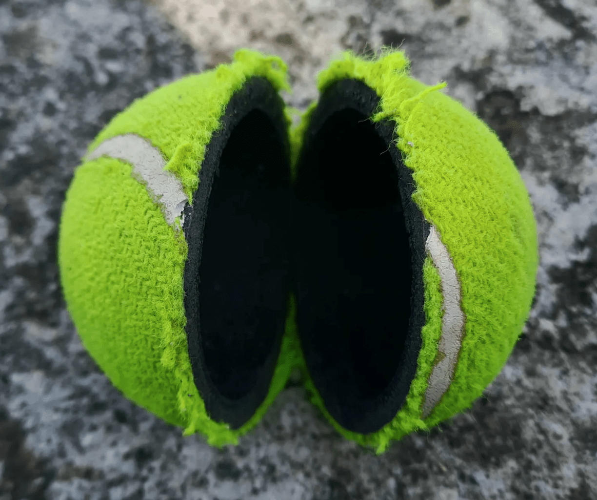 close up of black inside of tennis ball that has been cut in half