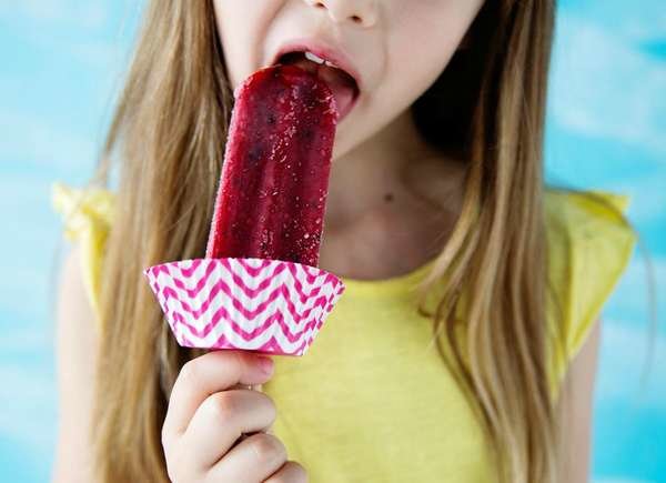 Girl eating popsicle protected with cupcake liner