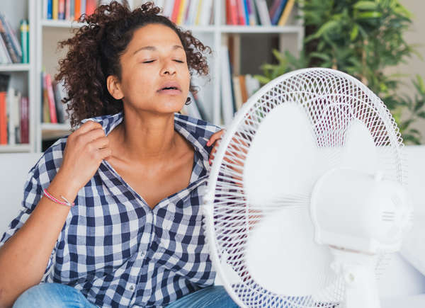 woman cooling herself off with fan