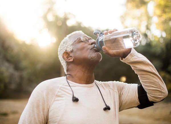 older African American man outside drinking from water bottle