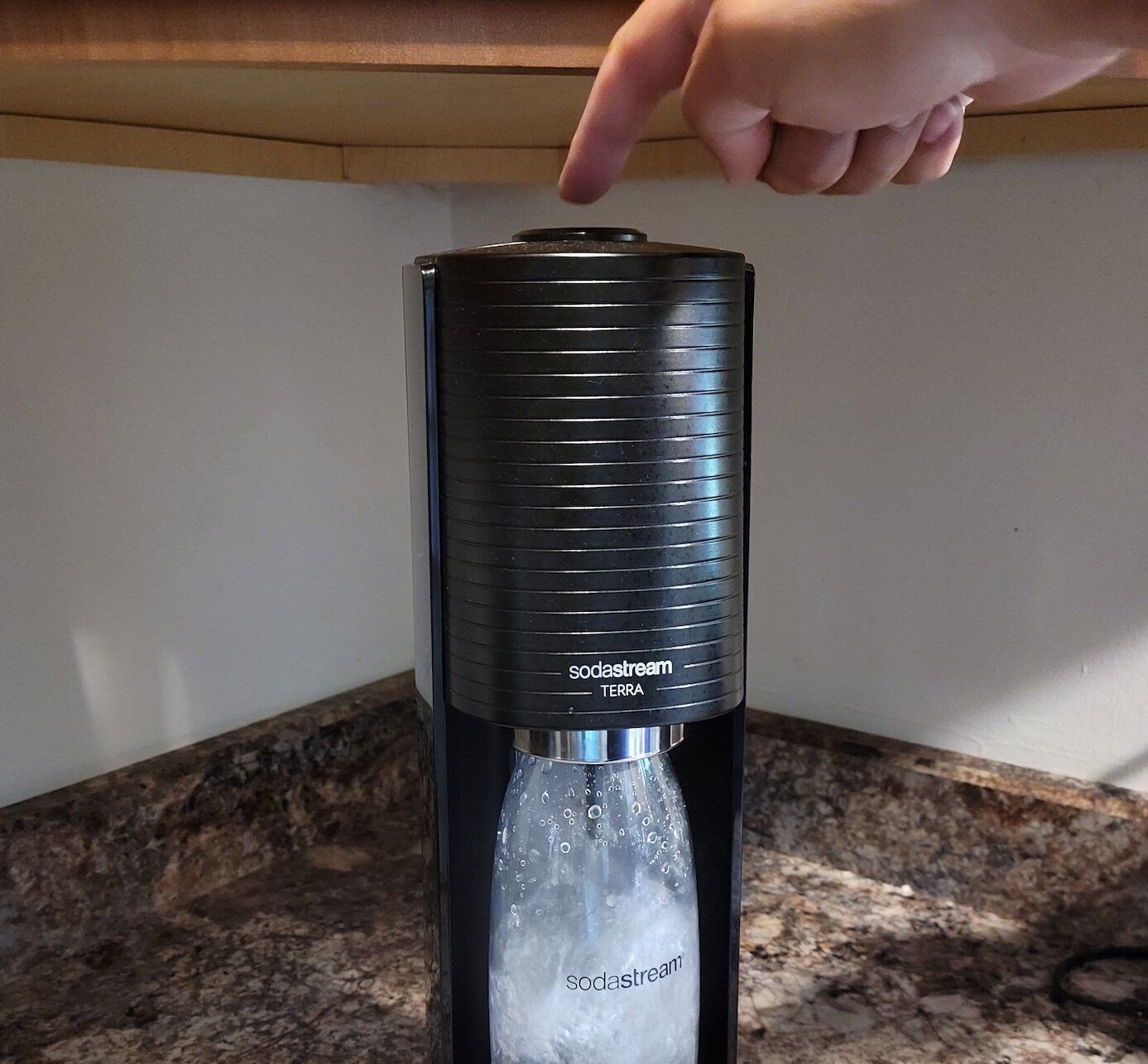 Person pressing button on SodaStream Terra for carbonation