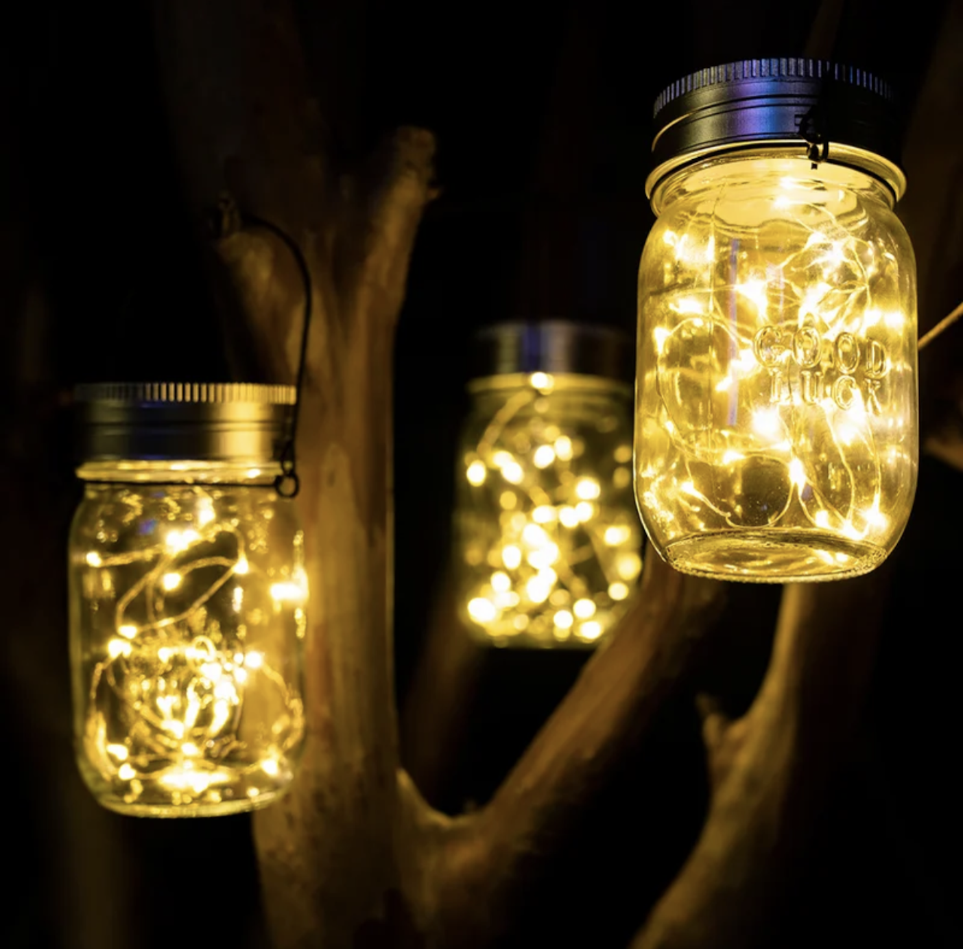 group of three lanterns made of mason jars with lights inside