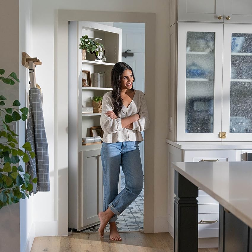 woman-in-front-of-murphy-bookcase-door-leading-out-of-a-white-kitchen