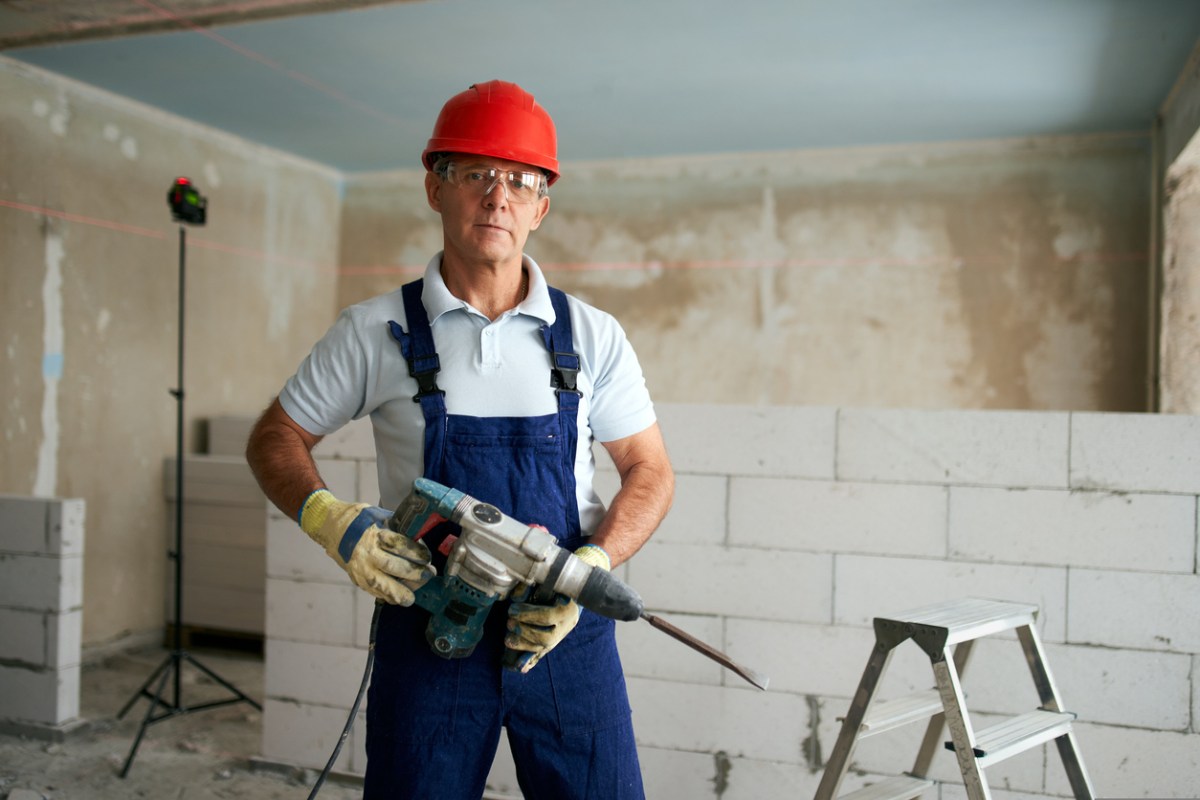 A person holding the best jackhammer option in a room under construction