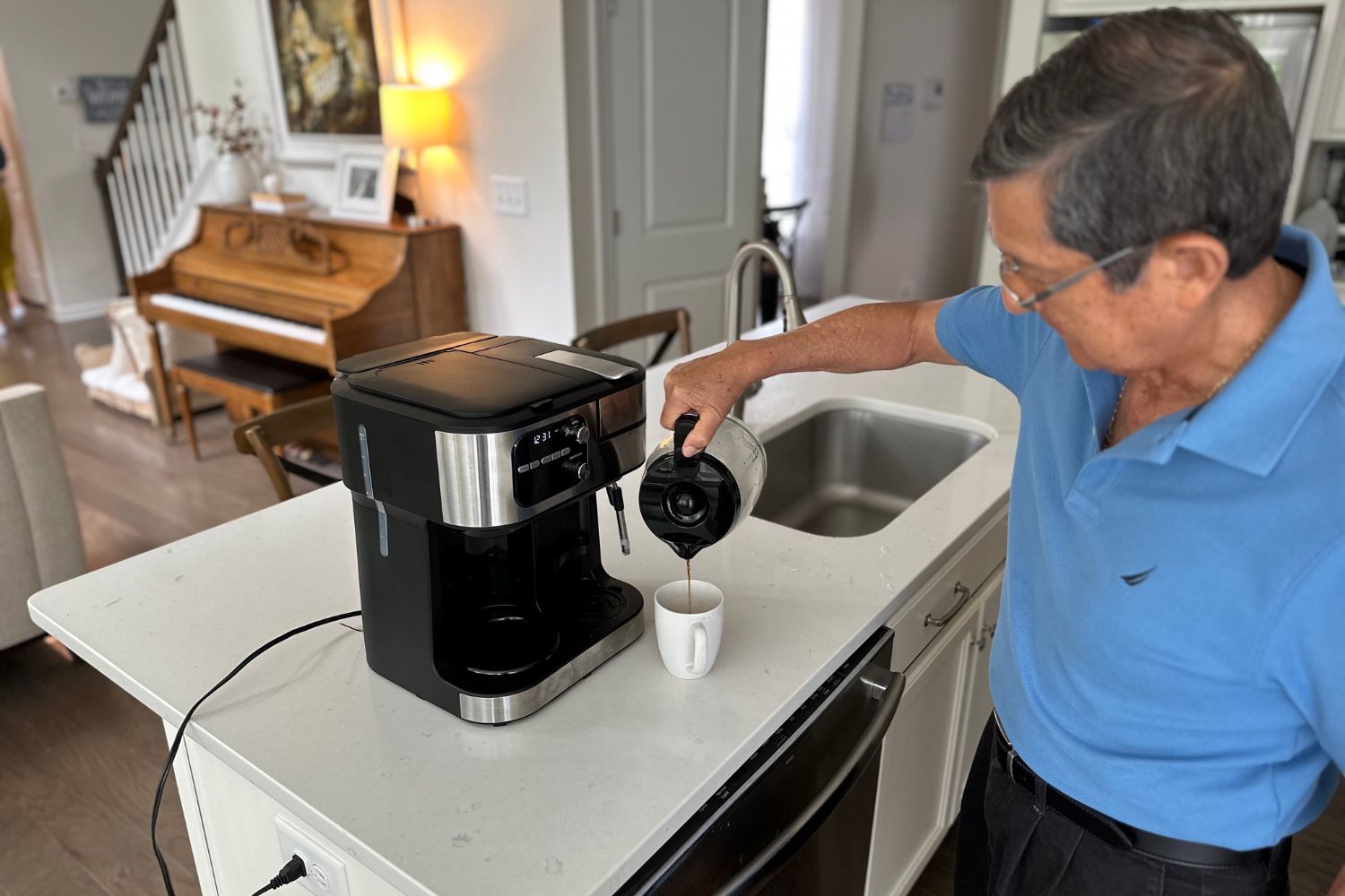 A person pouring a cup of coffee from the Cuisinart Coffee Center Barista Bar 4-in-1 Coffeemaker