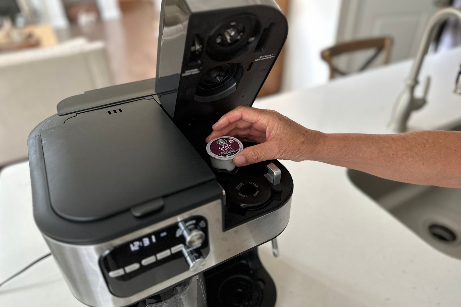 A person putting a coffee pod into the Cuisinart Coffee Center Barista Bar 4-in-1 Coffeemaker