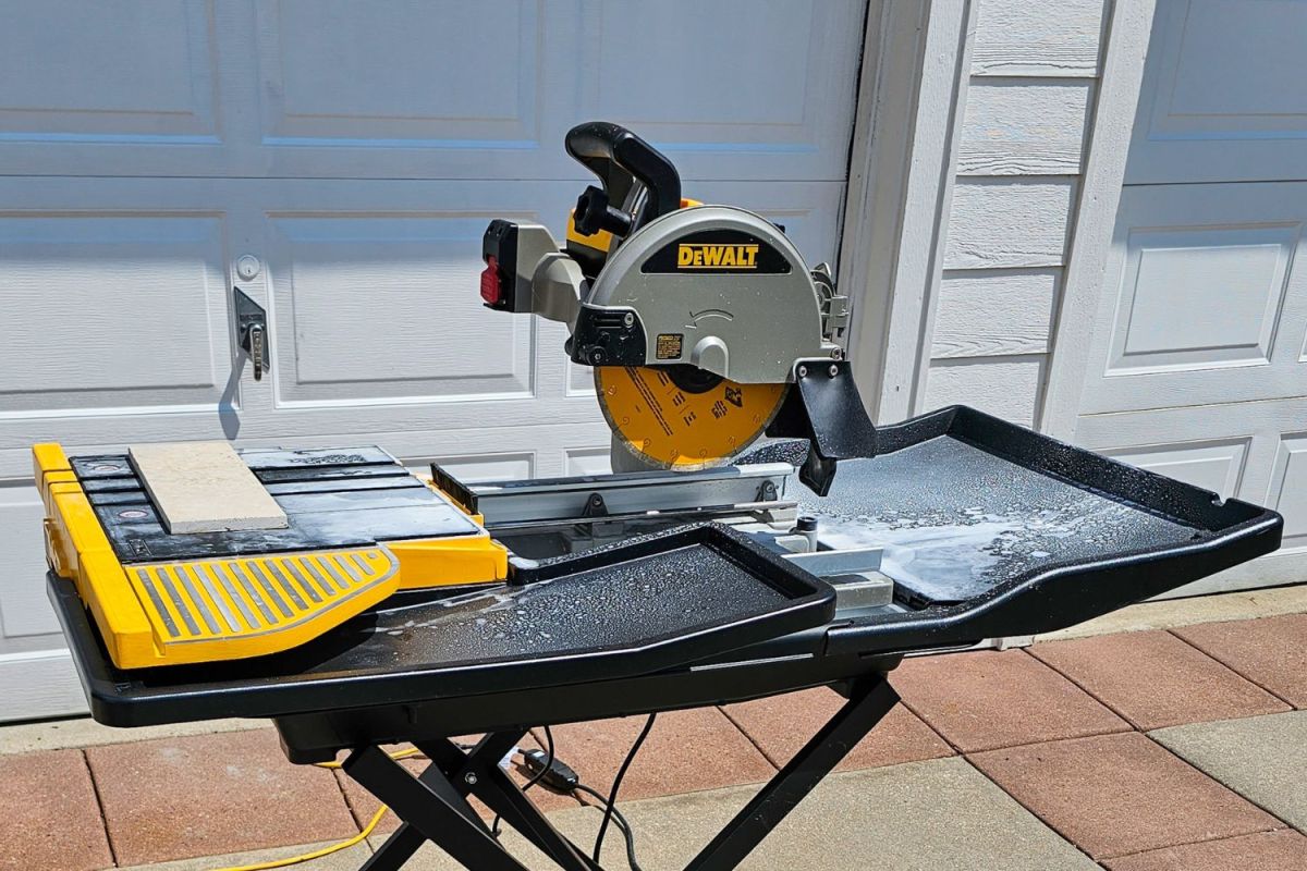 The DeWalt 10-inch wet tile saw set up to cut tiles in a driveway
