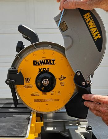 A person using the easy blade replacement feature on the DeWalt 10-inch wet tile saw to swap out the blade