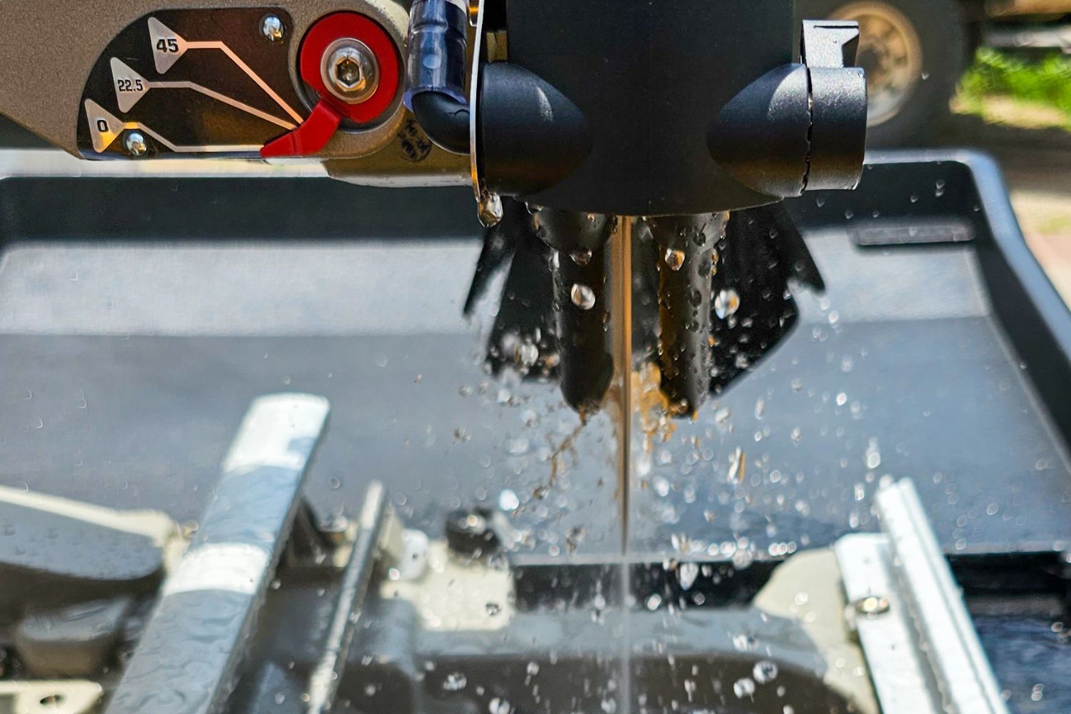 A close up of the blade of the DeWalt 10-inch wet tile saw spinning while water sprays onto it