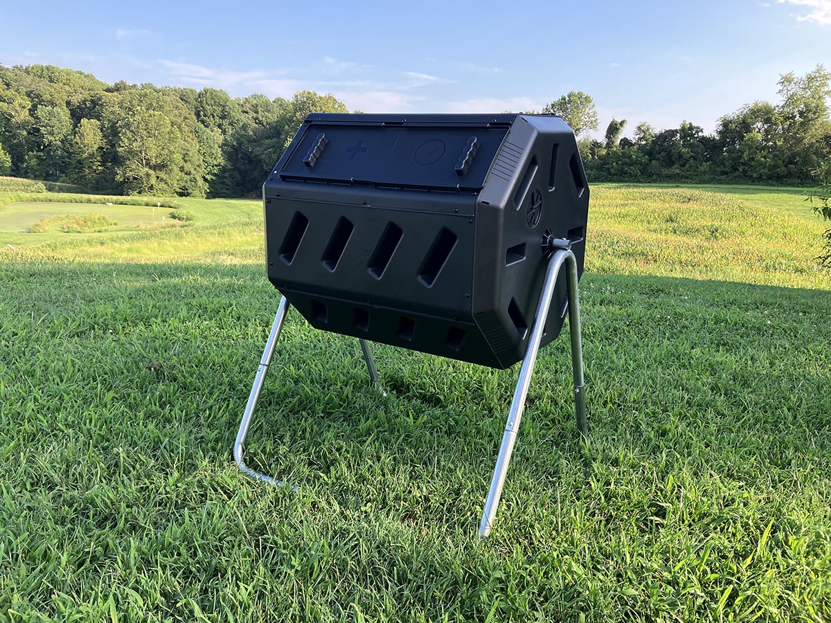 The FCMP Outdoor tumbling composter set up in a yard