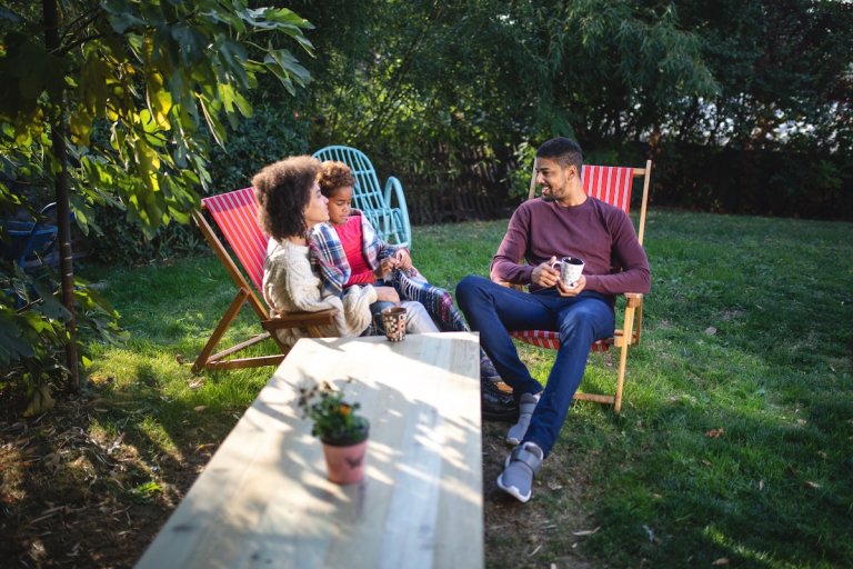 Backyard privacy ideas in a small outdoor space with family sitting in yard.