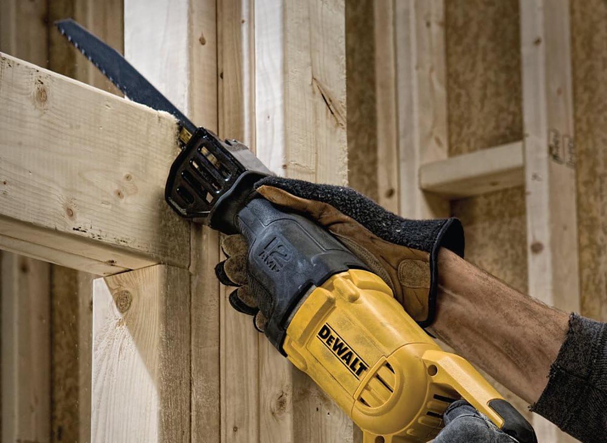 A person using the best DeWalt reciprocating saw to cut some framing in a house