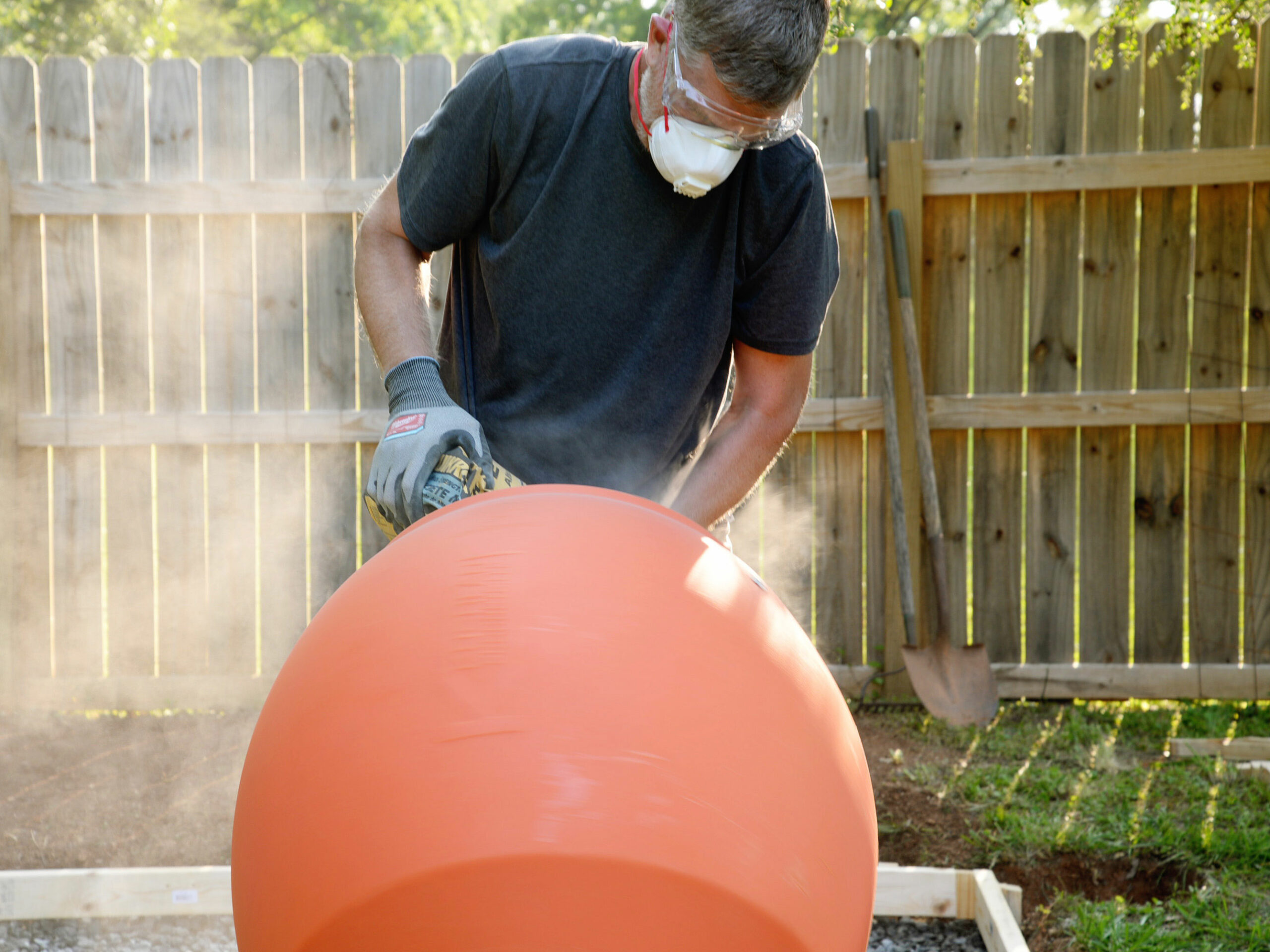 A person adding a bag of cement to the Kushlan concrete mixer