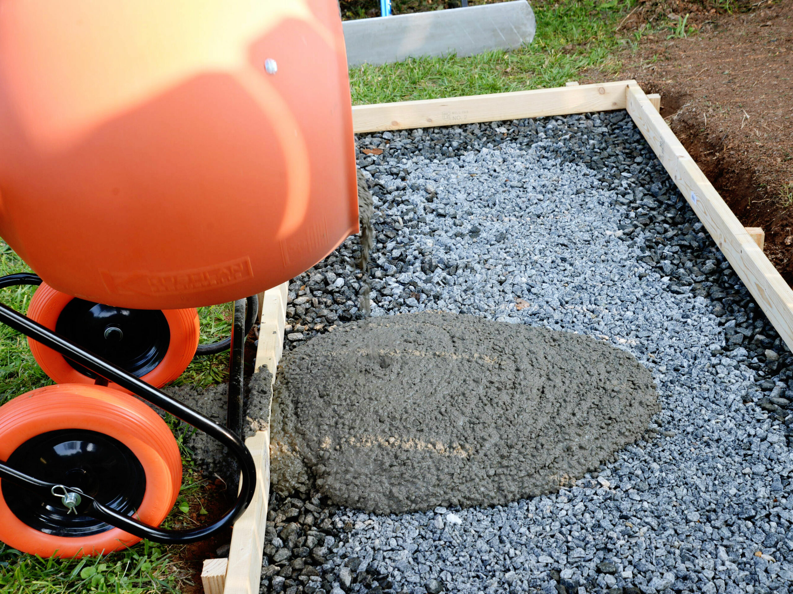 The Kushlan concrete mixer in use pouring a cement foundation in a yard