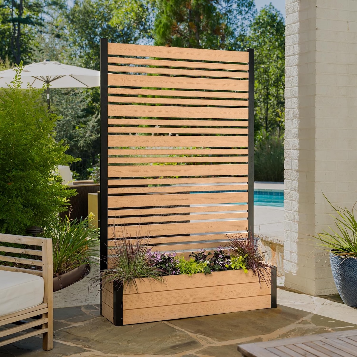 A planter with privacy screen in a backyard with a pool.