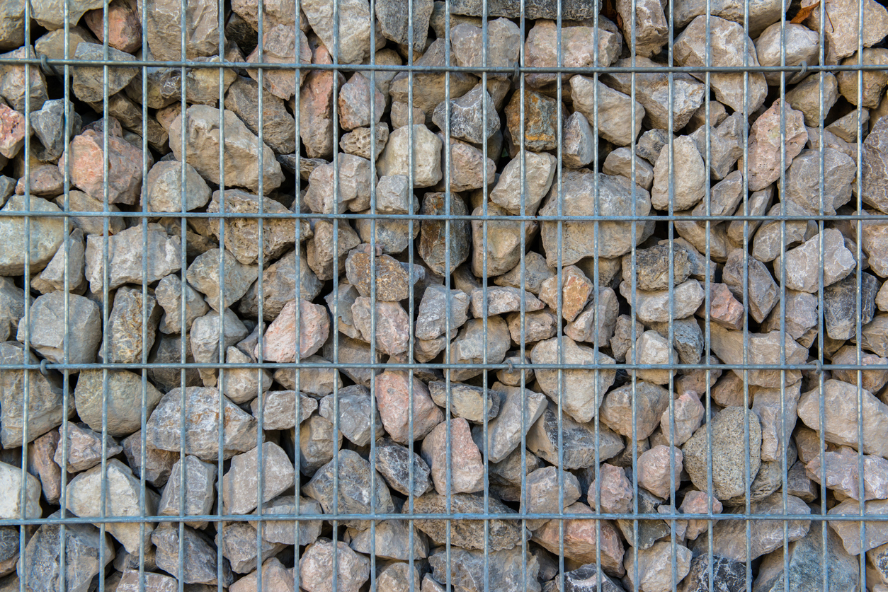 Closeup of a gabion retaining wall made of riprap and a metal wire frame