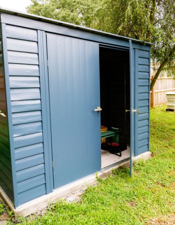 The ShelterLogic storage shed with one door open to reveal the tools inside
