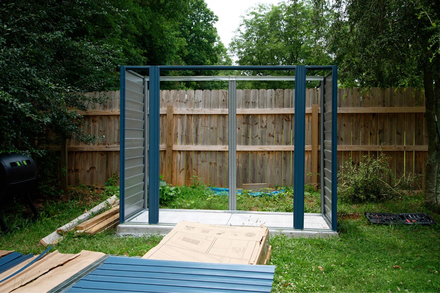 The frame of the ShelterLogic storage shed installed on a cement pad