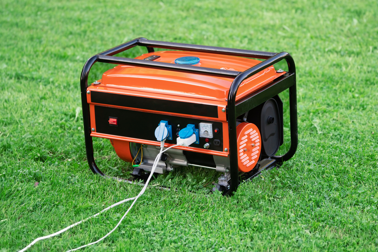 The Best Cheap Home Generators Option in a yard with two cords coming from it