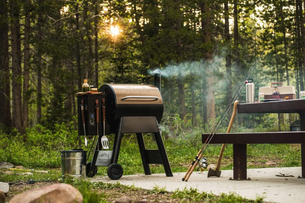 The best pellet grills under $1,000 option in use at a wooded campsite next to a picnic table