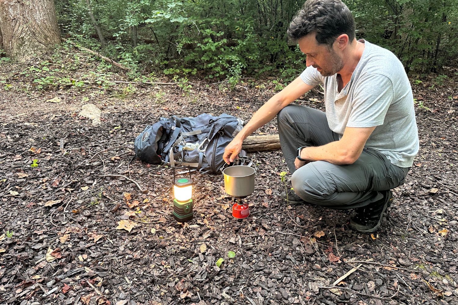 A person using the light from the Lepro LED lantern to see where to light a camping stove