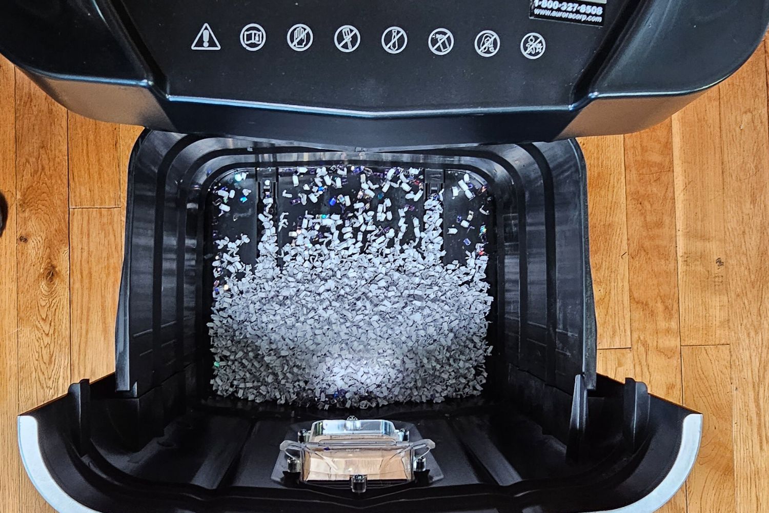 A look into the waste bin of the Aurora paper shredder, which has fine micro-cut paper shreds inside
