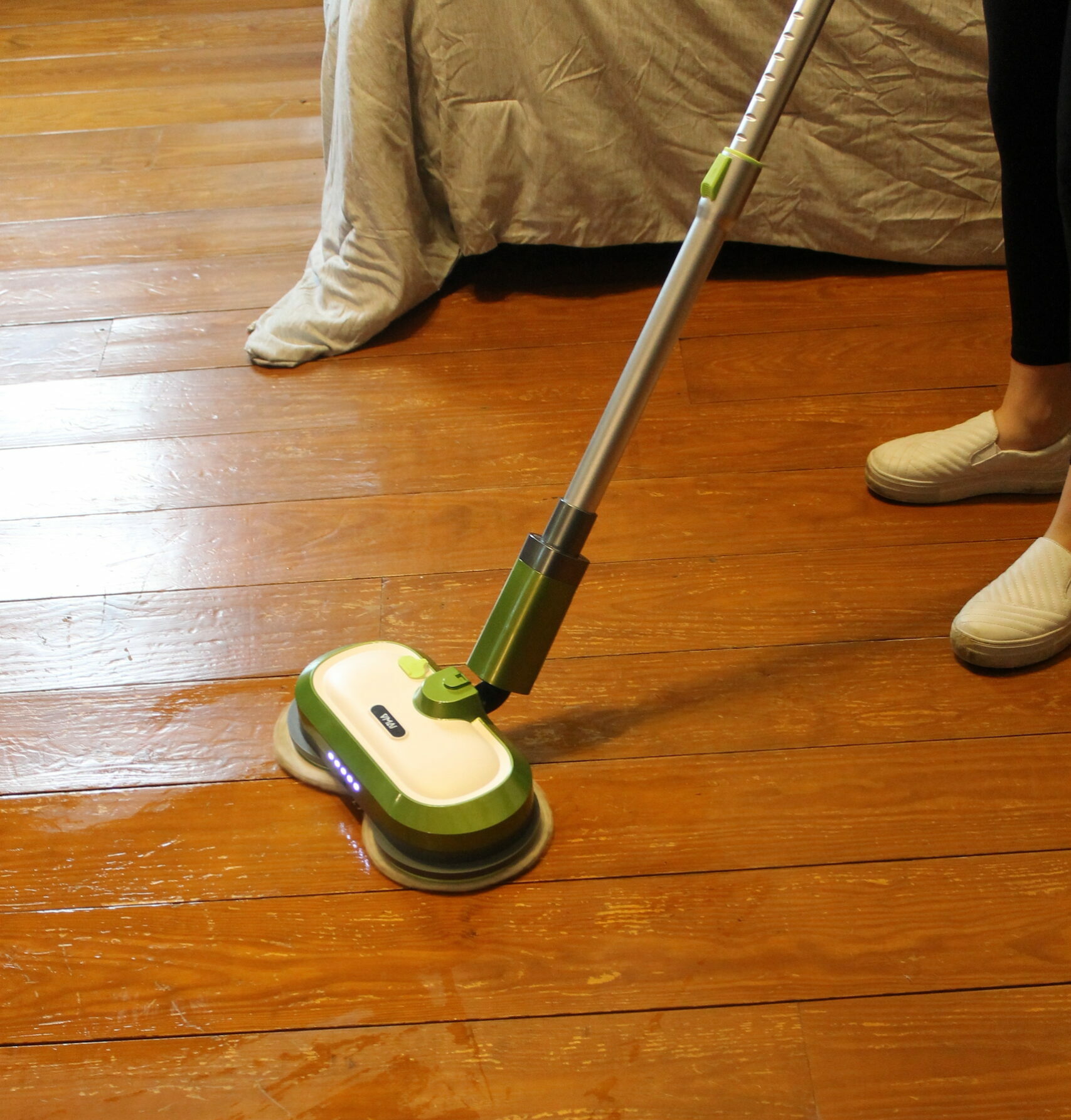 Tester using an electric mop on hardwood floors