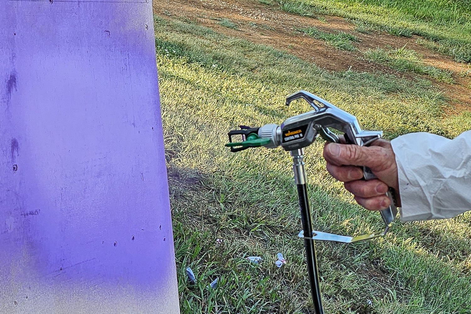 A person using the Wagner Paint sprayer to paint a white item purple