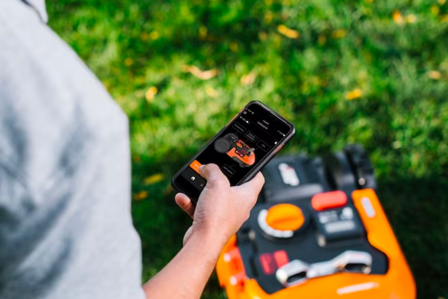 A person using the Worx app to control the Worx Landroid M robotic lawn mower