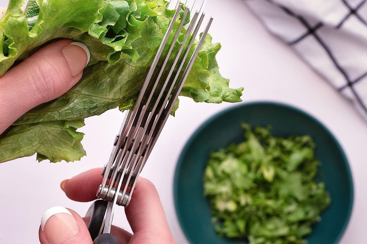 A person using the best herb scissors to slice herbs and leafy greens