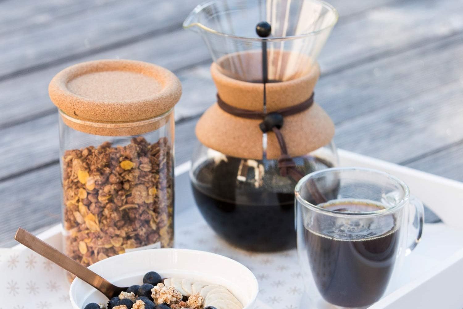 The best single-serve coffee maker option pictured next to a cup of brewed coffee and a bowl of oatmeal and granola