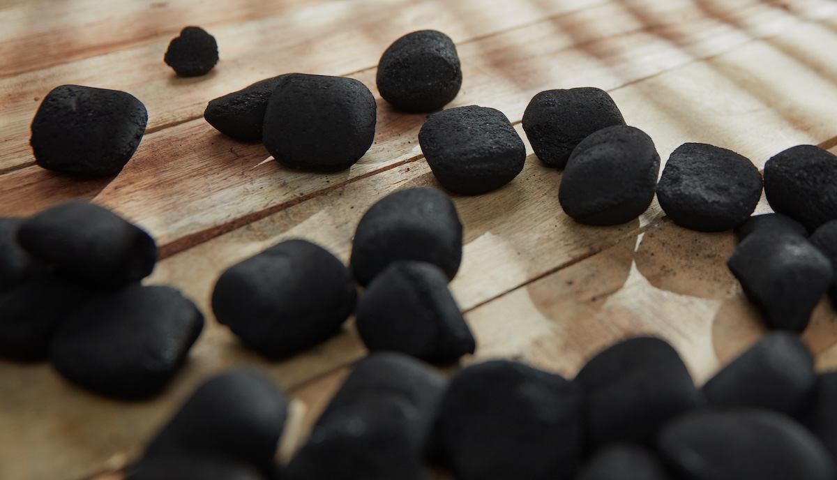 Charcoal briquettes on a wooden floor.