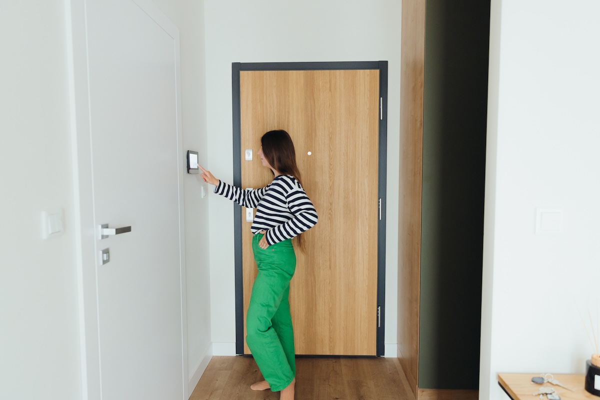 A woman wearing trendy green pants in an home with doors closed.