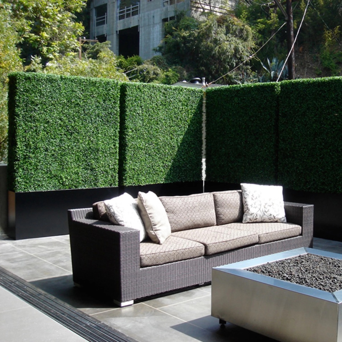 Faux boxwood greenery surrounding a modern patio area