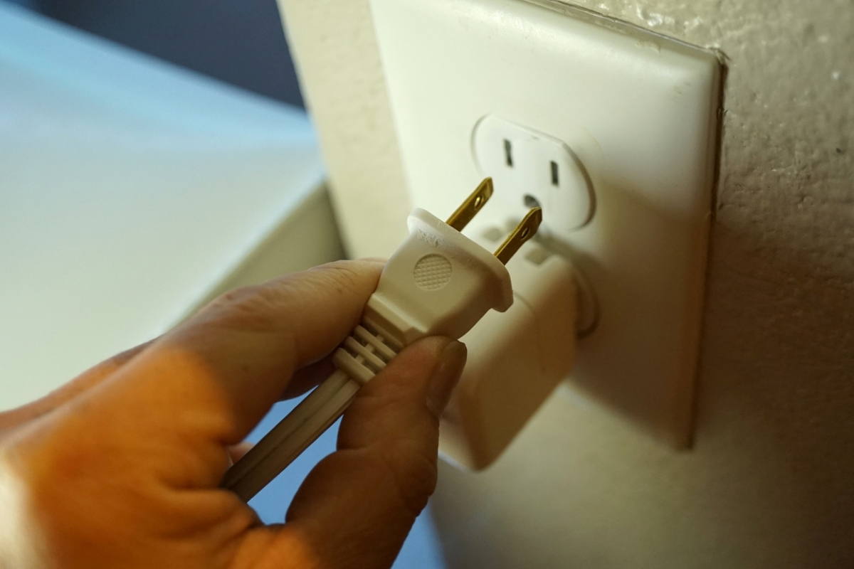 Person unplugging from socket