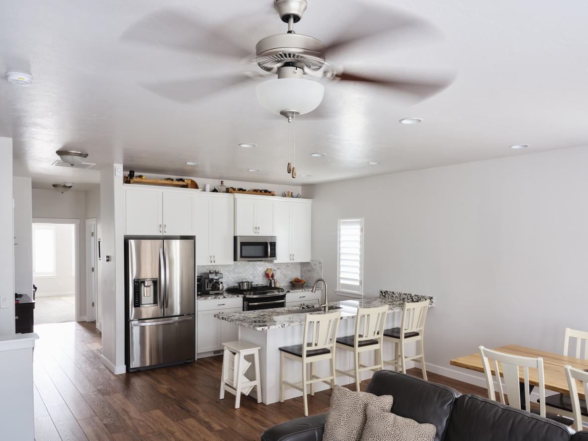 open plan living room and kitchen with ceiling fan spinning