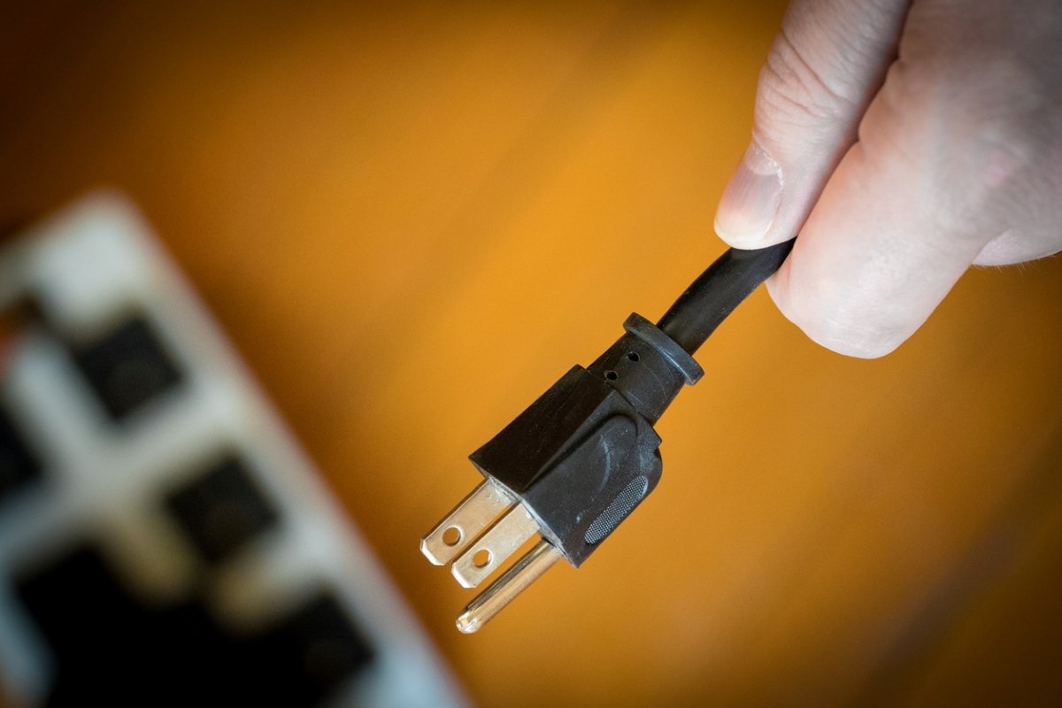 Person holding plug end of an electronic device.