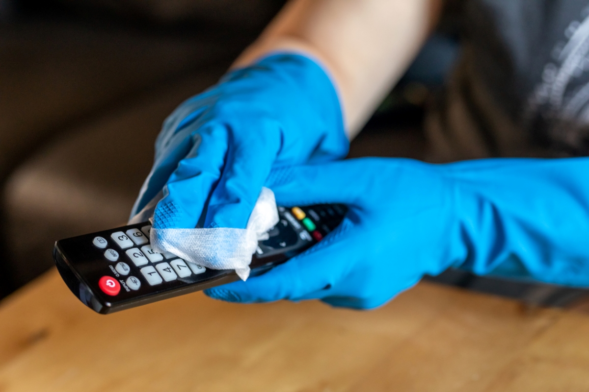 Person cleaning remote