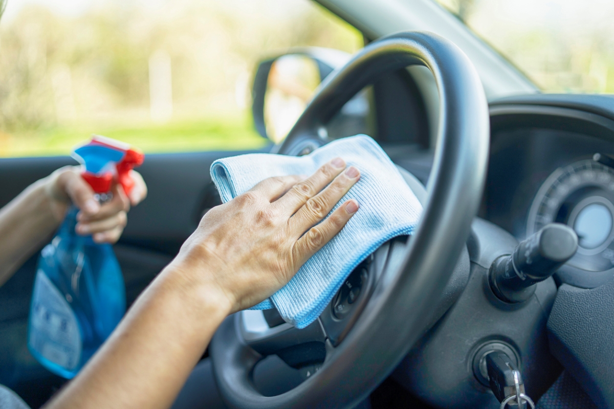 Person cleaning steering wheel