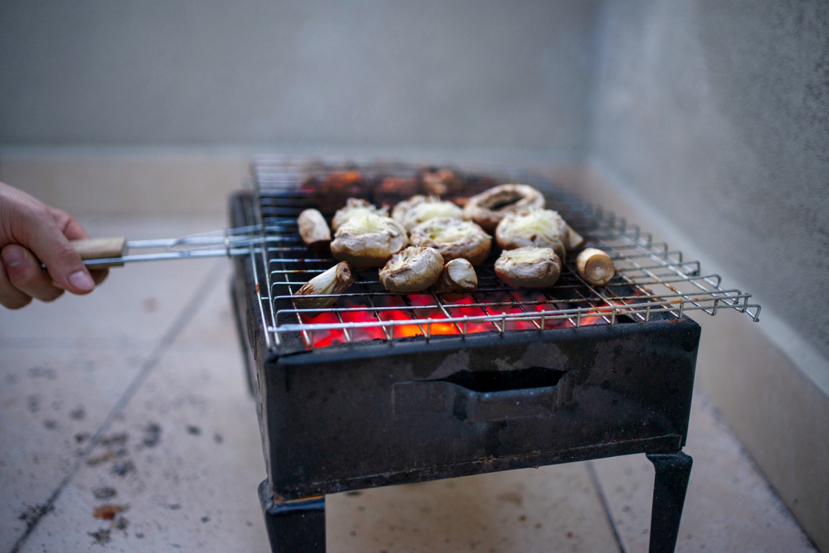 Person using small grill inside