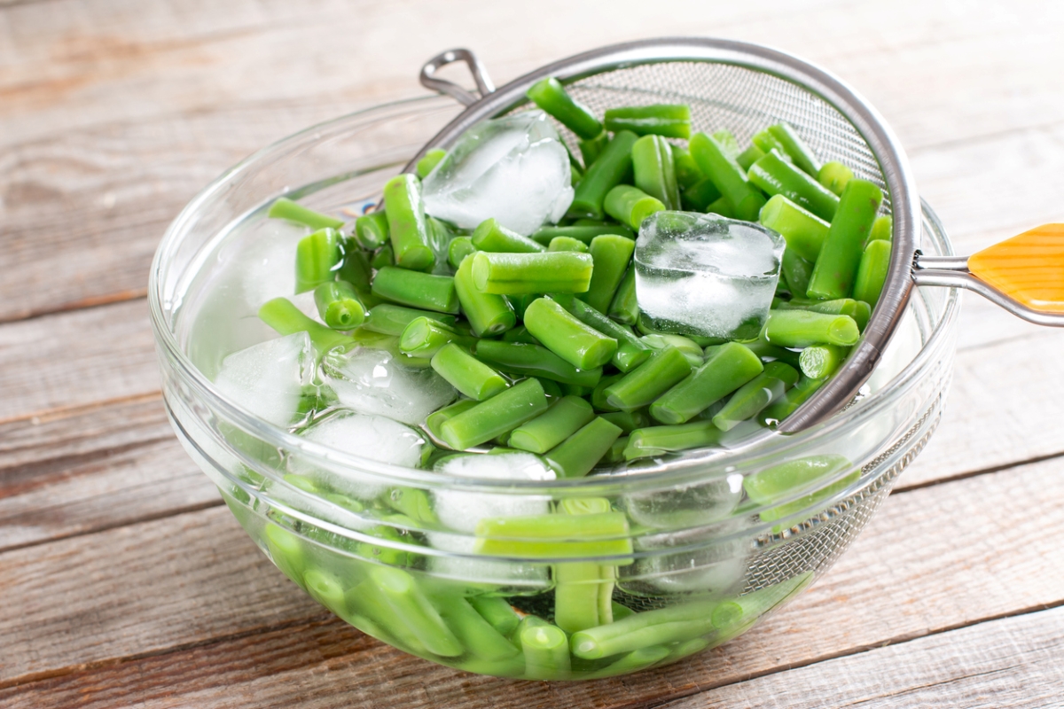 Blanching cooked green beans in cold water