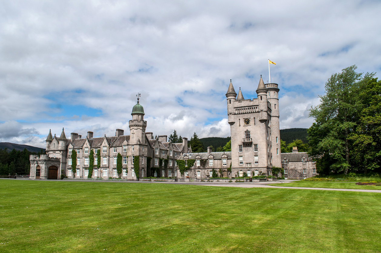 Balmoral Castle is the summer residence of the British Queen in Scotland. Old stone castle with several towers and a large garden.