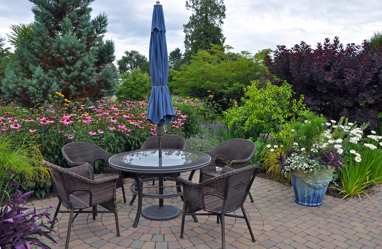 garden patio with table and four patio chairs and umbrella